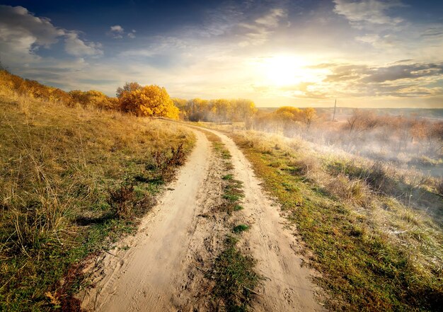 Morning fog over country road in autumn