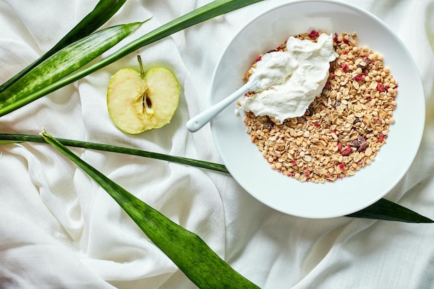 Morning granola breakfast with greek yougurt and apple