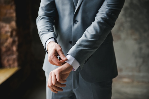 Morning of the groom. Groom morning preparation. Young and handsome groom getting dressed