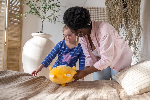 Morning at home. a woman and a girl making bed in the\
morning