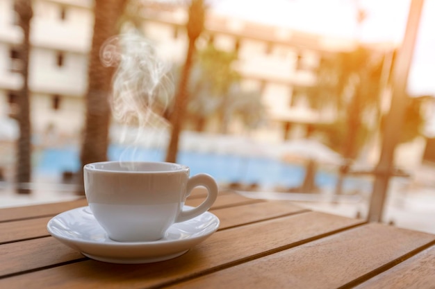 海の背景にテーブルの上の朝のホットコーヒー