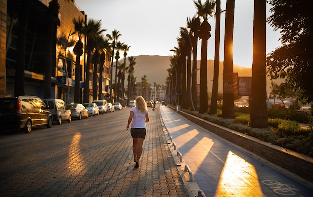 Morning jog of a young woman on the road in the city of Marmaris.Turkey