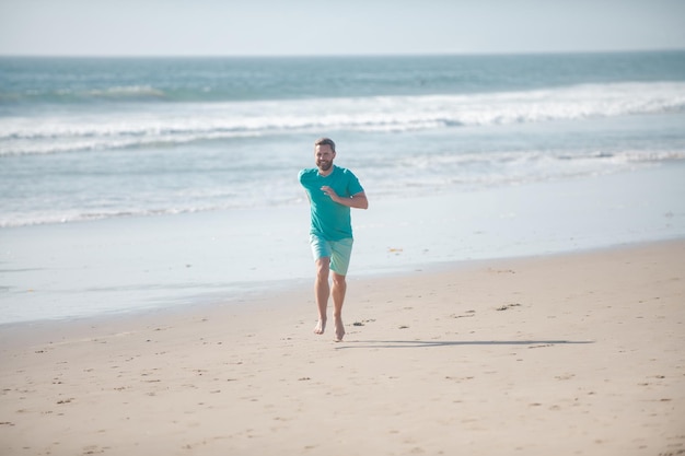 바다 근처의 모래 해변에서 아침 조깅을 하거나 해변에서 달리는 바다 남자