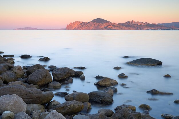 海の朝の風景。石のあるビーチ