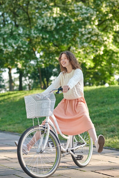 公園での朝。公園で自転車に乗ってかわいい生姜の女の子