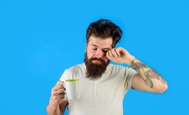 Morning refreshment and drink tired sleepy man with beverage in cup refreshment and energy bearded