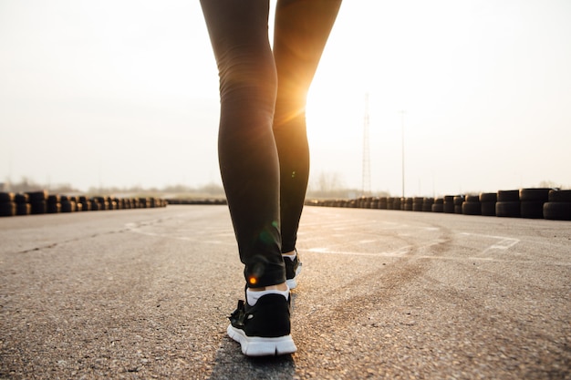 Morning run of a young girl on the street in black leggings and sneakers