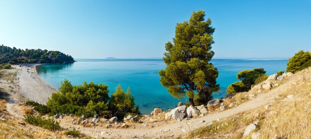 Mattina spiaggia sabbiosa di kaviou. vista dall'alto di estate (nikiti, sithonia, halkidiki, grecia). le persone sono irriconoscibili. due colpi punto panorama.