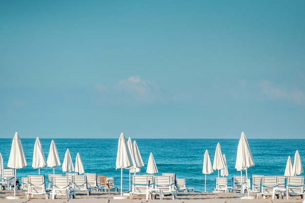 Morning sea, beach, empty sun beds for vacationers. Vacation concept.