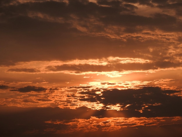 オレンジ色の雲と太陽のある朝の空