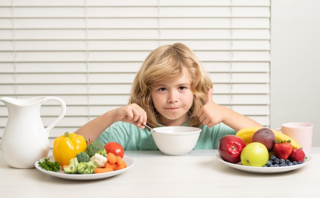 Morning snack with muesli cereal granola funny blonde little boy having breakfast milk vegetables an