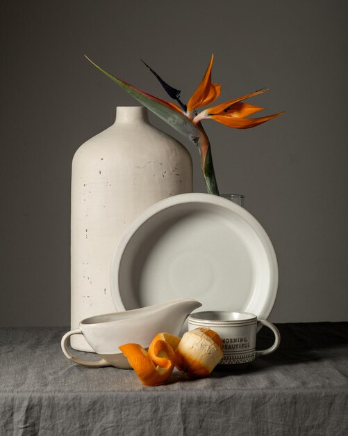 写真 お茶、クロワッサン、オレンジ色のエキゾチックな花と朝の静物カップ