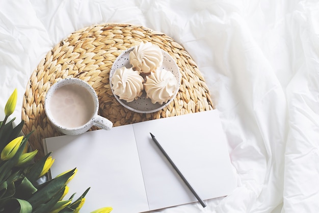 Morning still life with cup of coffe, tulips and sketch book. top view