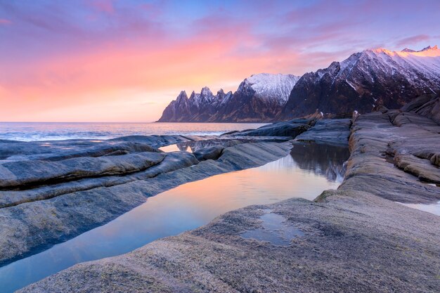 Photo morning surf on a stony beach among the mountains