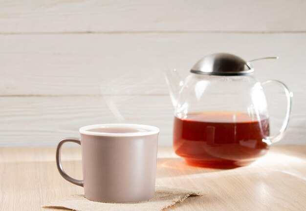 Morning tea A glass teapot with tea a mug with tea on a linen napkin