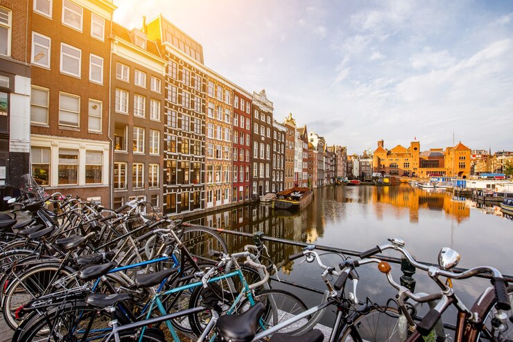 Photo morning view on the beautiful buildings and bicycles on the damrak avenue in amsterdam