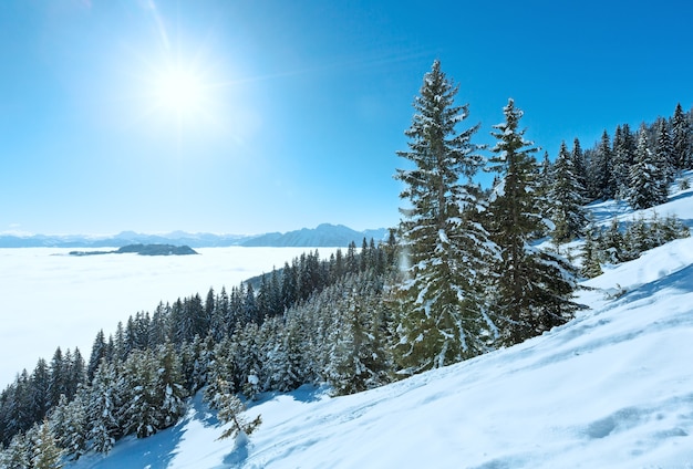 Morning winter mountain landscape with clouds in below valley (Hochkoenig region, Austria) and sunshine