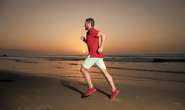 Morning workout activity healthy man running on sunrise beach energetic summer