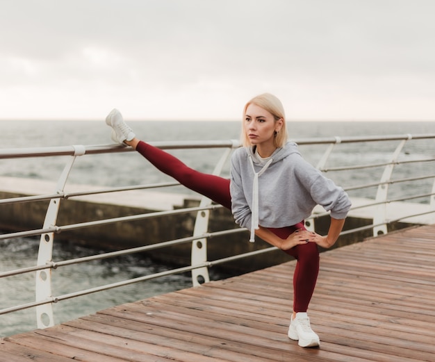 Morning workout Healthy lifestyle concept Young attractive woman in sportswear does leg stretching