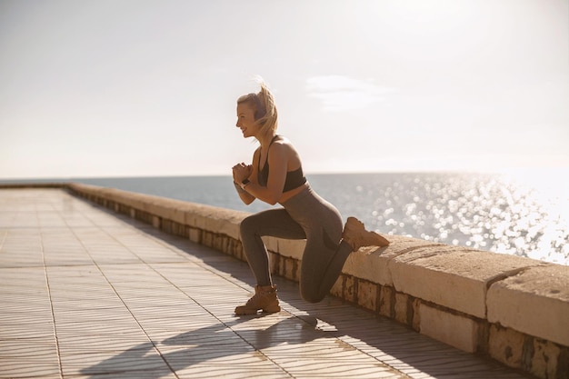 Allenamento mattutino di giovane donna vicino al mare