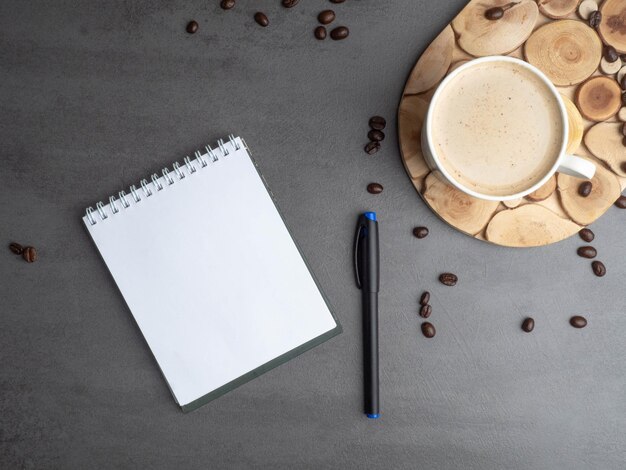 Morning workplace as cup of coffee coffee beans and notepad for notes Minimalism concept