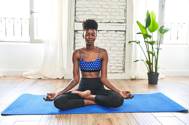 Morning yoga practice in the living room an African woman embod