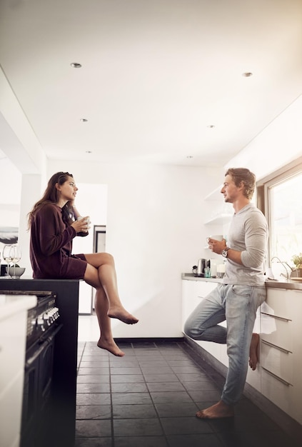 Mornings at home make the best coffee dates Shot of a happy young couple enjoying a relaxing cup of coffee together in the kitchen