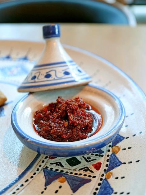 Marocchina harissa chili paste in una mini tajine pot servita con piatto marocchino