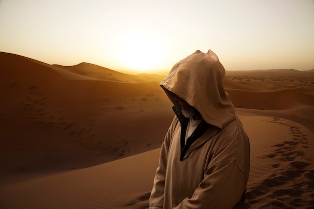 Moroccan man walking on a dune in the Sahara desert