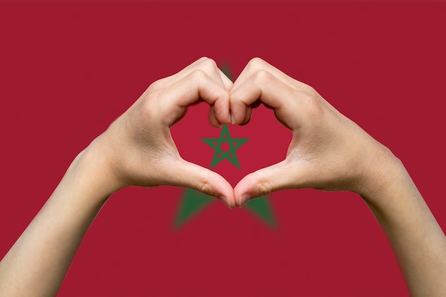 Foto bandiera del marocco con due mani forma di cuore esprimere amore o affetto concetto di sostegno o donare a