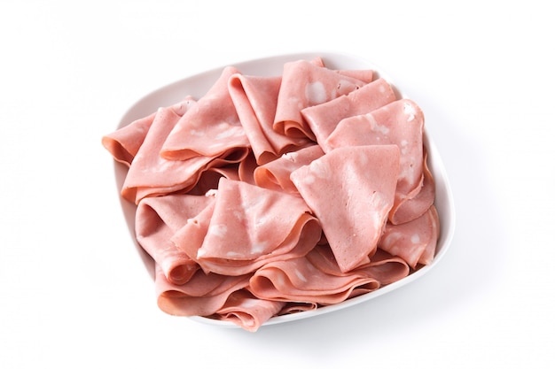 Mortadella slices on white plate isolated on white surface.