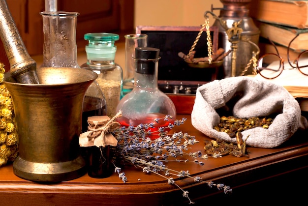 Mortar and pestle near potions on wooden table closeup of healing herbs alchemist stuff old pharmacy