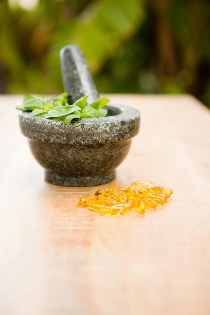 Mortar and pestle with herb and pills