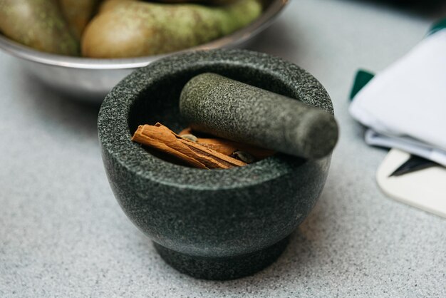 Foto mortero e pestello con spezie su un tavolo di cucina ingredienti per la lezione di cucina