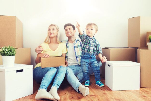 Photo mortgage people housing and real estate concept happy family with boxes moving to new home