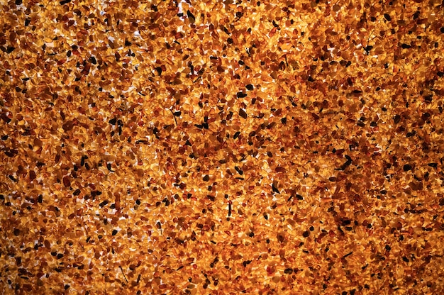 Mosaic of amber stones in contour sunlight as background close up selective focus