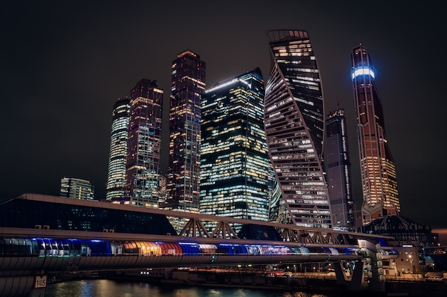Московский городской ночной вид с небоскребами и футуристический мост через реку