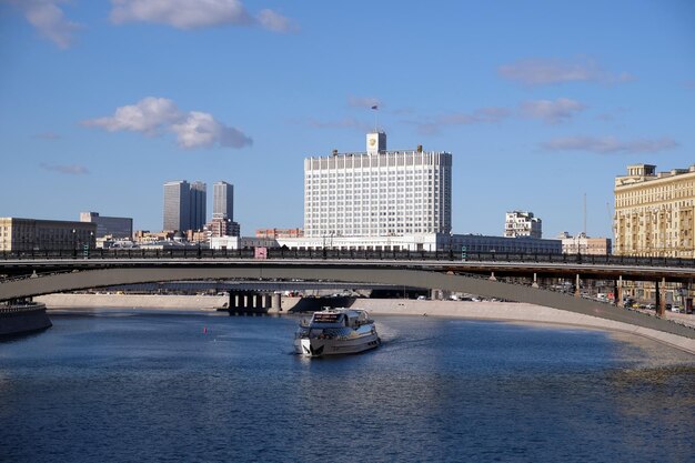 Фото Городской пейзаж москвы с зданием правительства российской федерации, кораблем и мостом