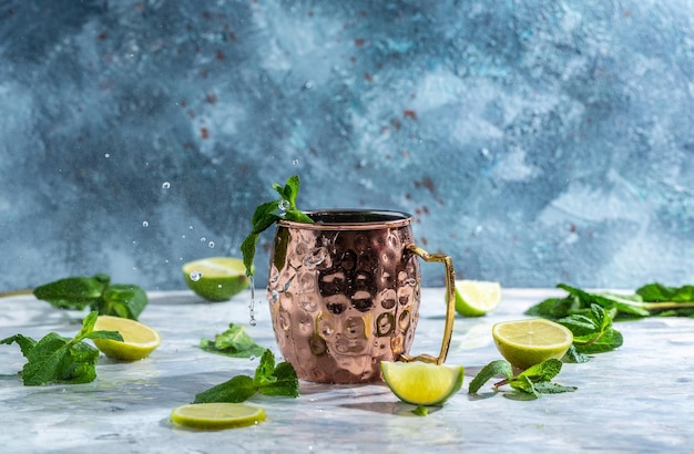 Moscow mule alcoholic cocktail in copper mug with lime ginger beer vodka and mint