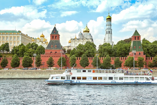 Moscow Russia May 29 2019 A modern river ship in the center of Moscow sails past the Kremlin Picturesque modern urban architecture Tourism rest in the city river transport