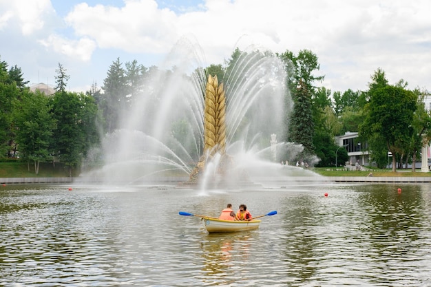 Moscow, summer 2022. VDNKh. People ride rental boats in the park on the lake. High quality photo