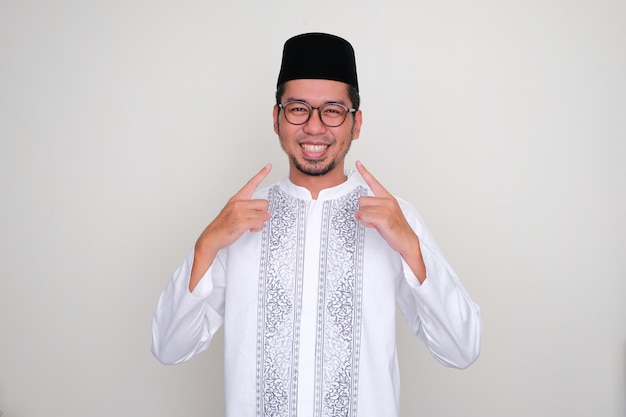 Moslem Asian man pointing to his mouth with happy expression