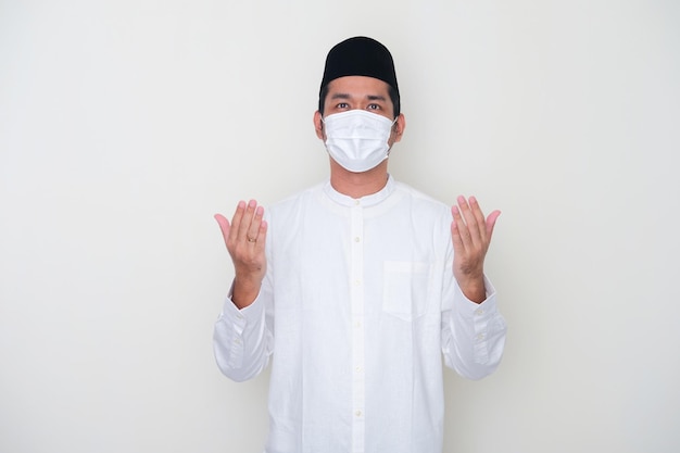 Moslem Asian man praying while wearing medical mask