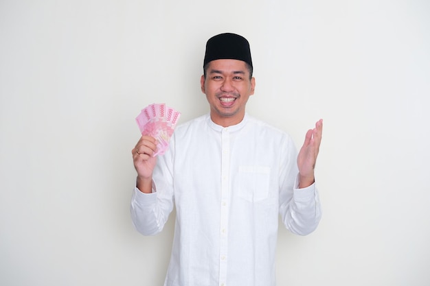 Moslem Asian man showing grateful gesture while holding paper money