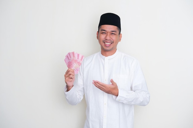 Moslem Asian man smiling happy while holding paper moner