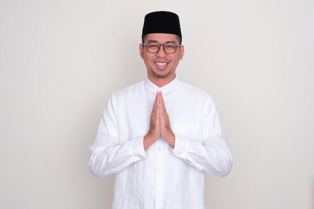 Мусульманский азиатский мужчина улыбается, тепло приветствуя