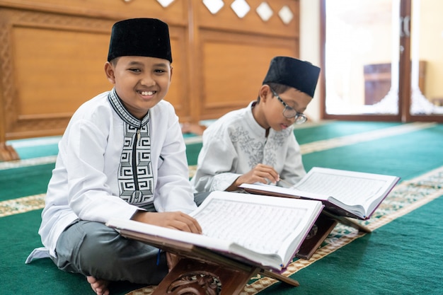 Moslim Aziatische jongen bestfriend die Koran leest