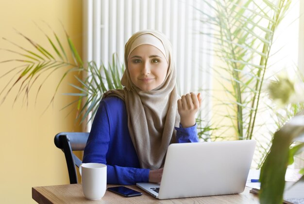 Moslim aziatische vrouw die op kantoor werkt met laptop