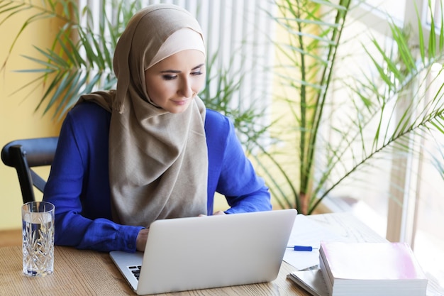 Moslim aziatische vrouw die op kantoor werkt met laptop