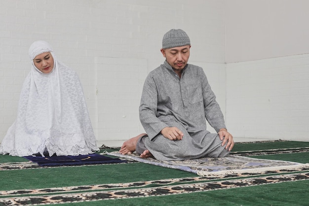 Moslim die thuis samen salah bidt en de laatste beweging doet op de salat-procedure genaamd tashahhud of tas